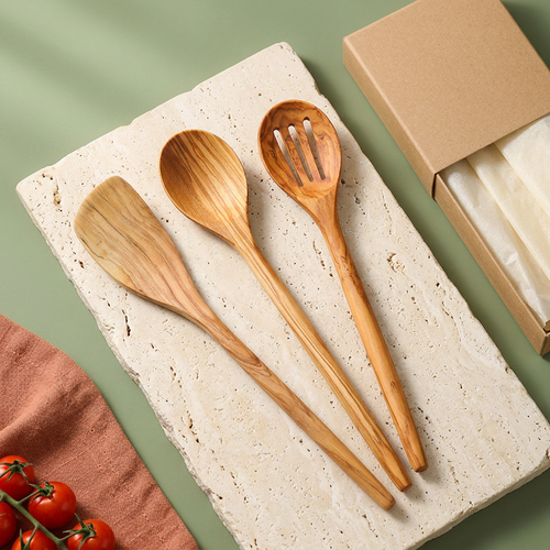 Three wooden kitchen utensils styled against sage and cream